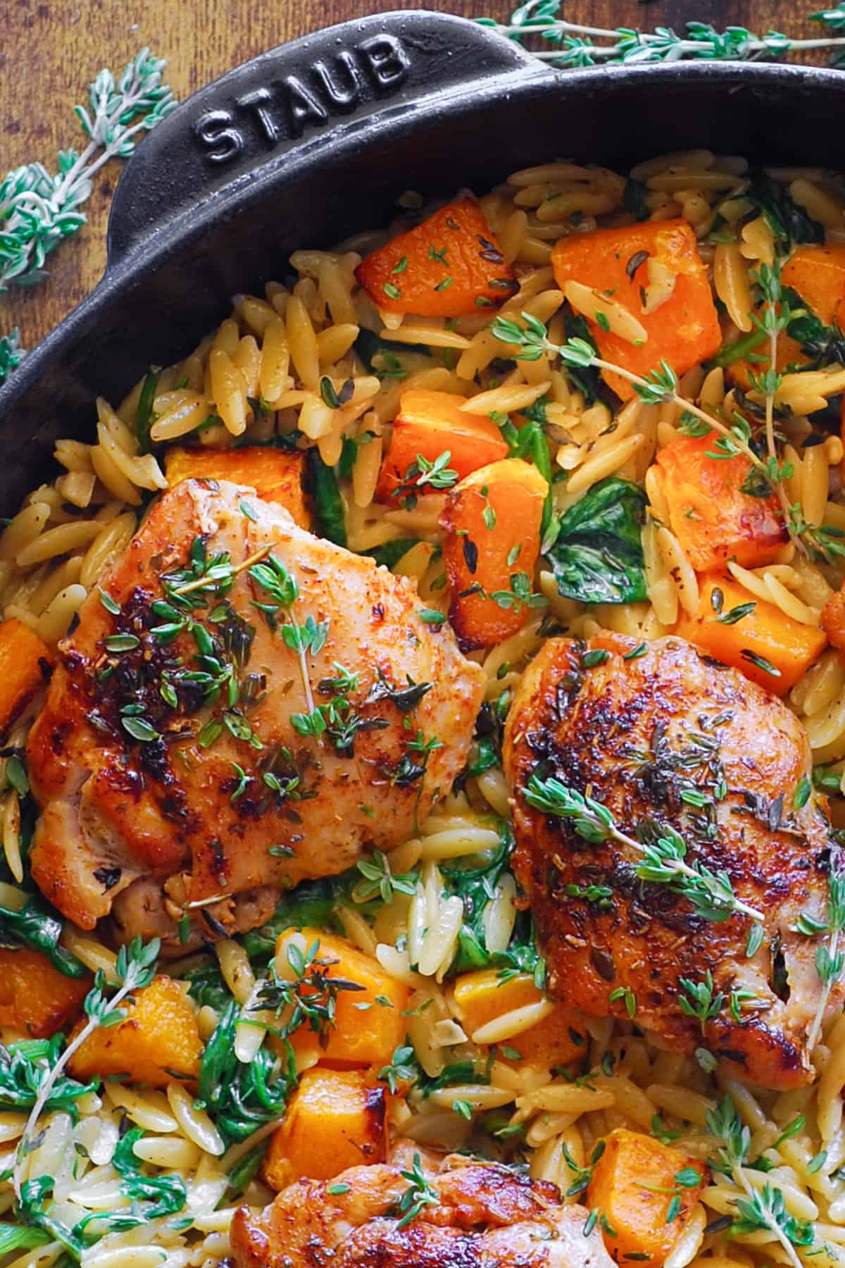 chicken orzo with butternut squash and spinach in a cast iron skillet.