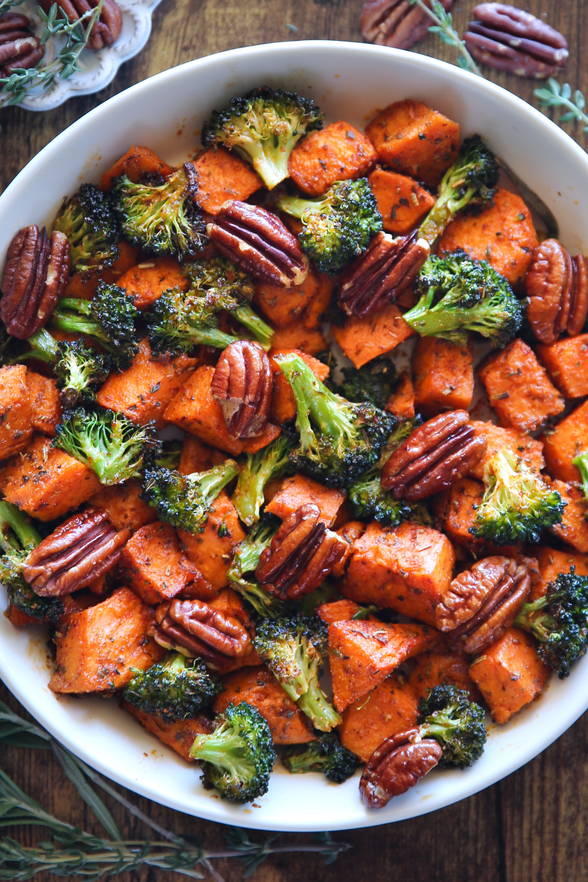 sweet potatoes and broccoli with pecans in a white bowl.