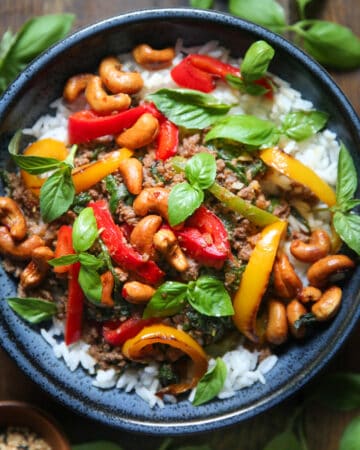 Thai basil beef over rice in a blue bowl.