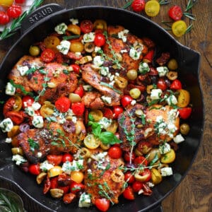Greek Chicken with Tomatoes, Feta, Olives, and Lemon Juice - in a cast iron pan.