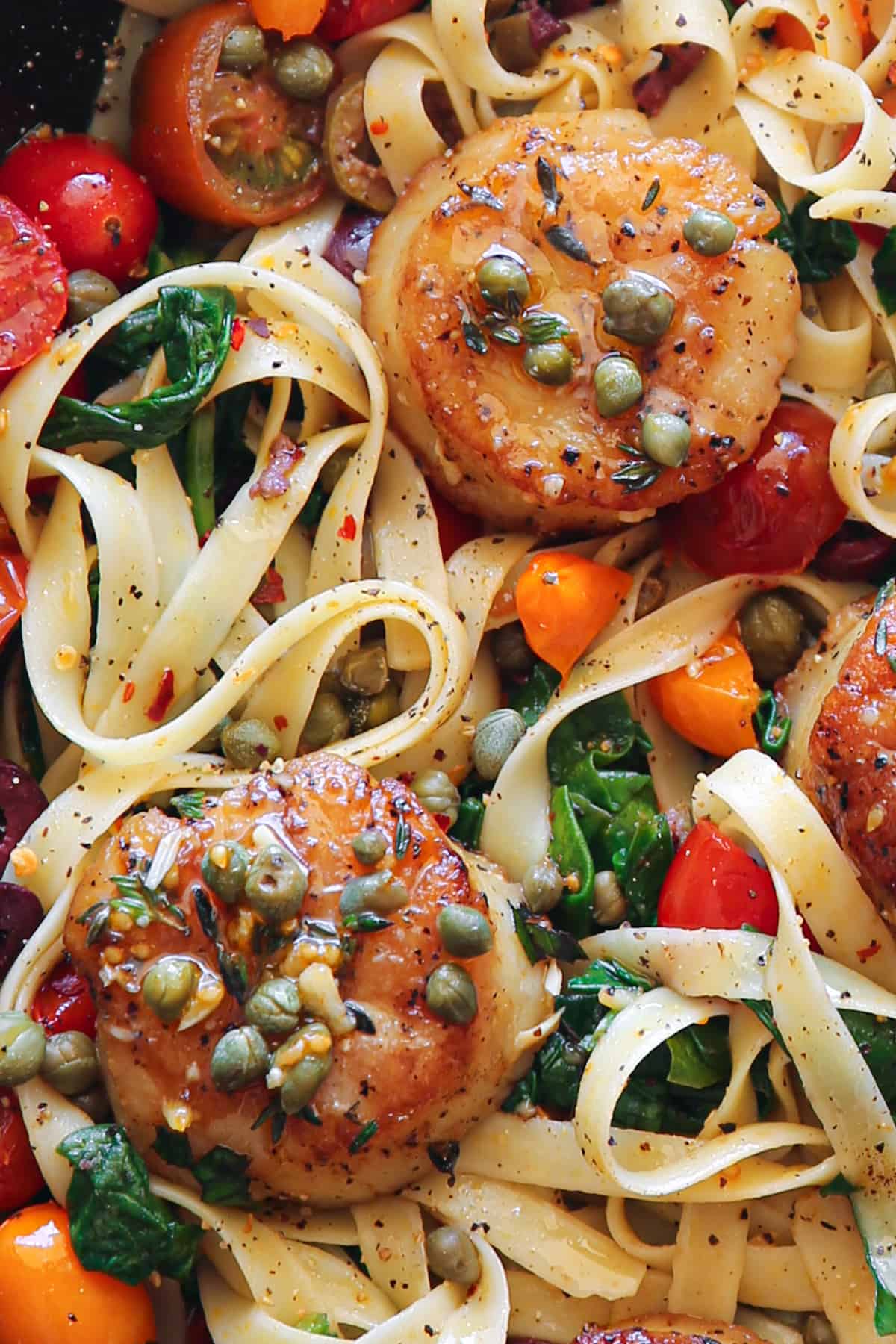 Scallop Pasta with Tomatoes and Spinach in a Lemon Garlic Butter Sauce.