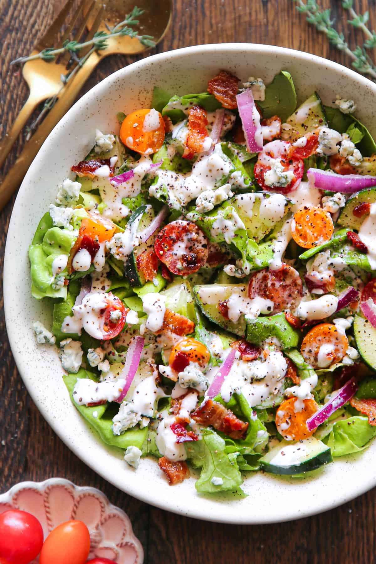Tomato Cucumber Lettuce Salad with Bacon and homemade Blue Cheese Dressing - in a white bowl.