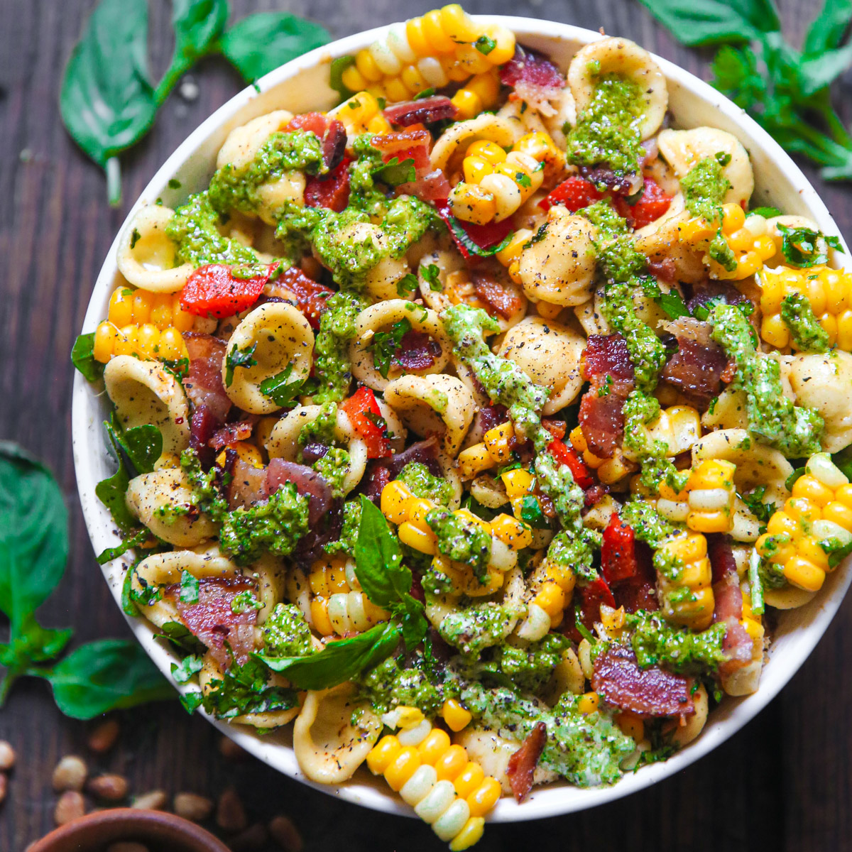 Corn Bacon Pasta Salad with Bell Peppers and Creamy Pesto Dressing - in a white bowl.