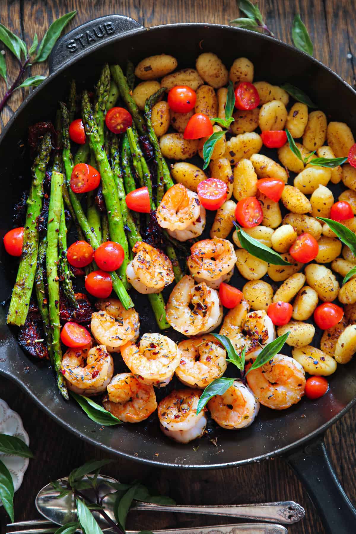 Shrimp Gnocchi with Asparagus, Sun-Dried Tomatoes, and Cherry Tomatoes - in a cast-iron skillet.