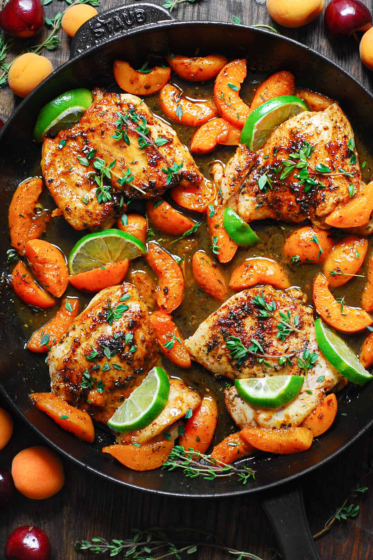 Chicken with cooked sliced Apricots, Honey-Lime Sauce, garnished with lime slices - in a cast iron skillet.