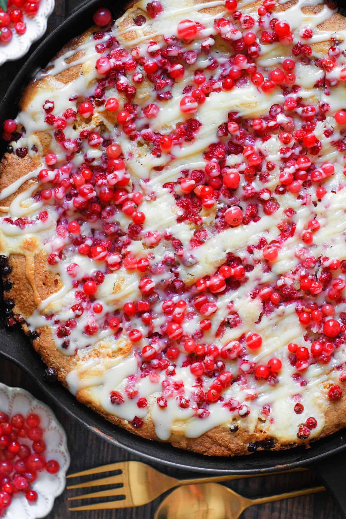 Red Currant Cake with the Cream Cheese Filling and with the Cream Cheese Topping drizzled on top - in a cast iron skillet.
