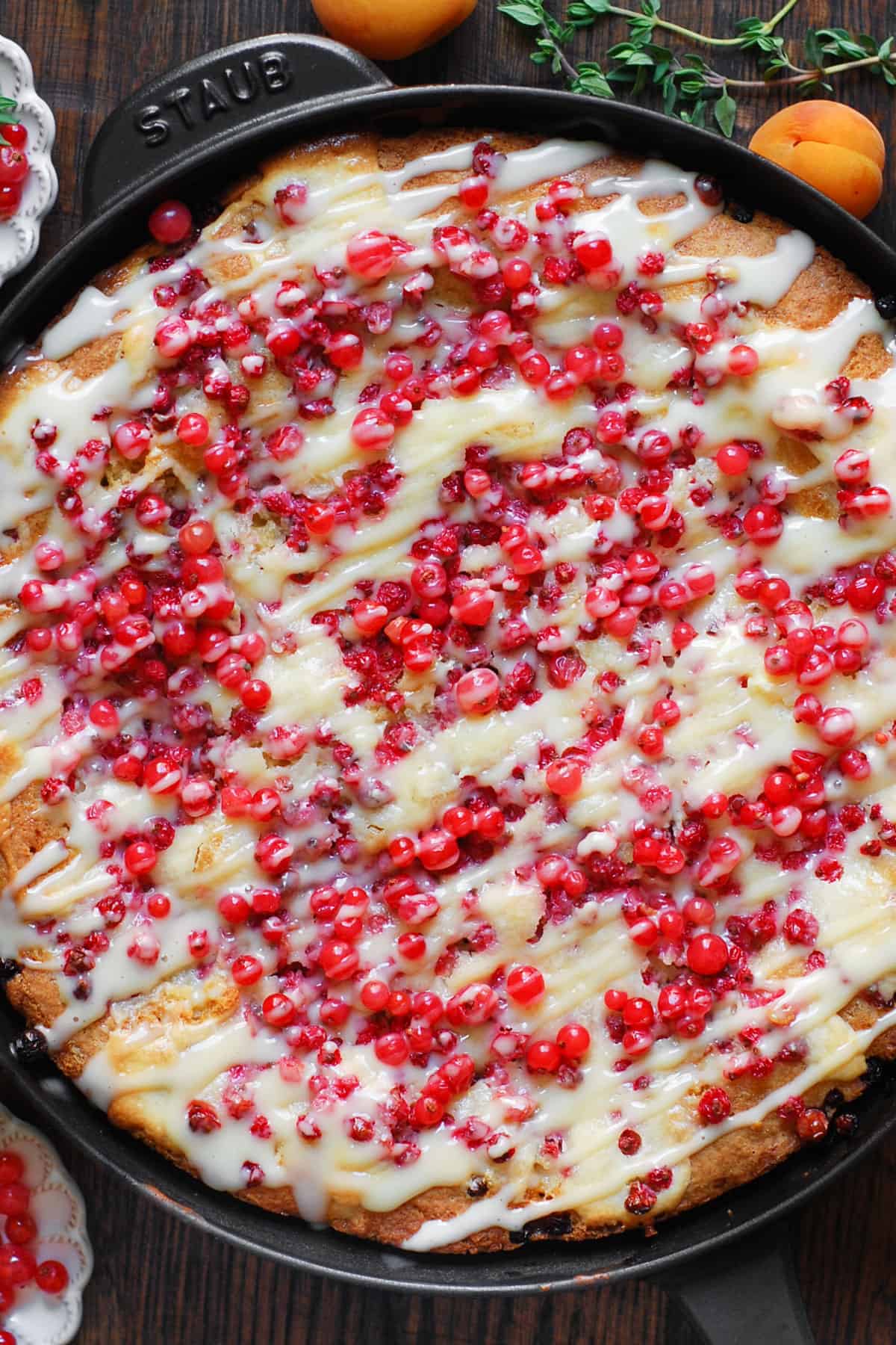Baked Red Currant Cake with the Cream Cheese Filling and with the Cream Cheese Topping drizzled on top - in a cast iron skillet.