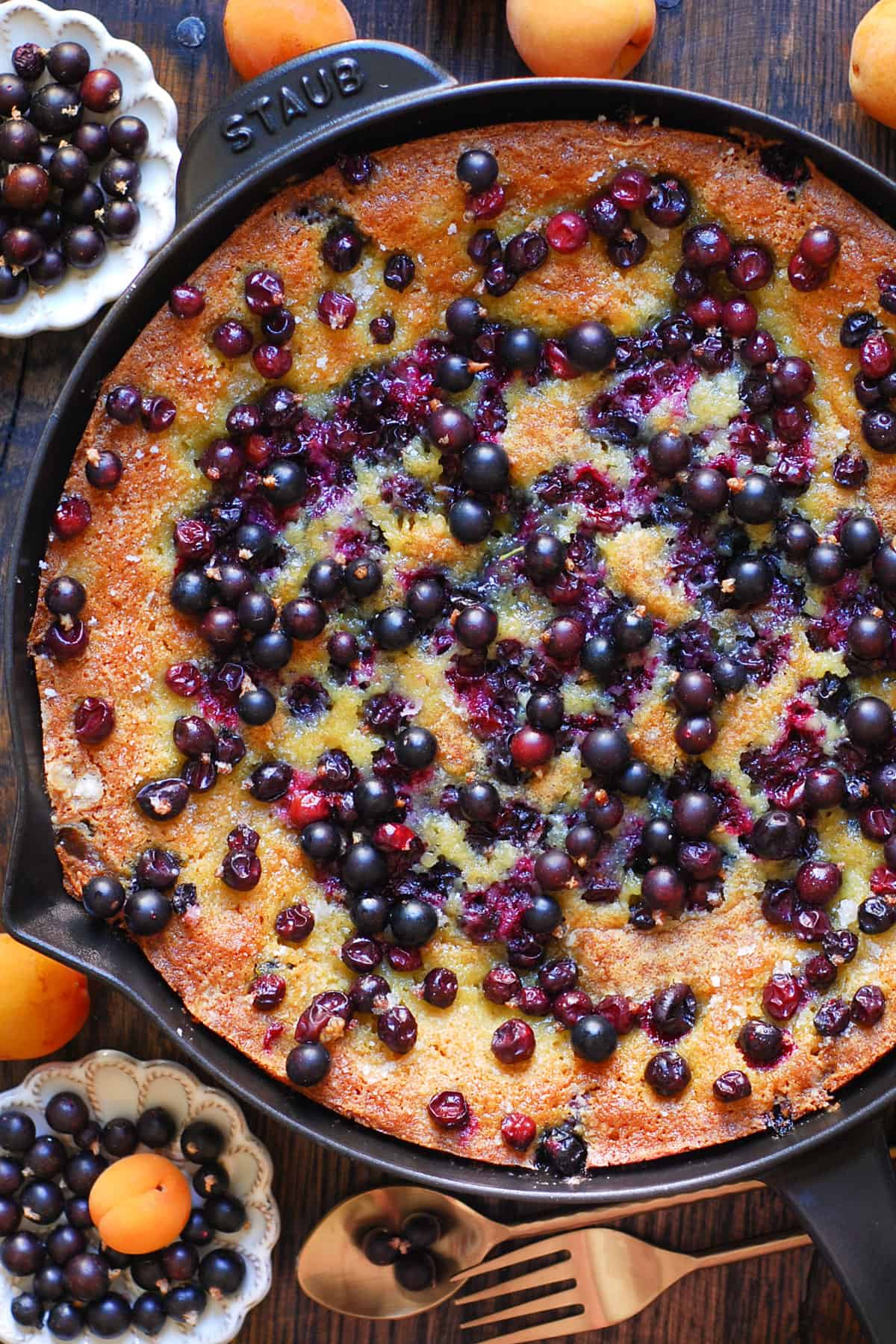 Black Currant Cake topped with fresh black currants - in a cast iron skillet.