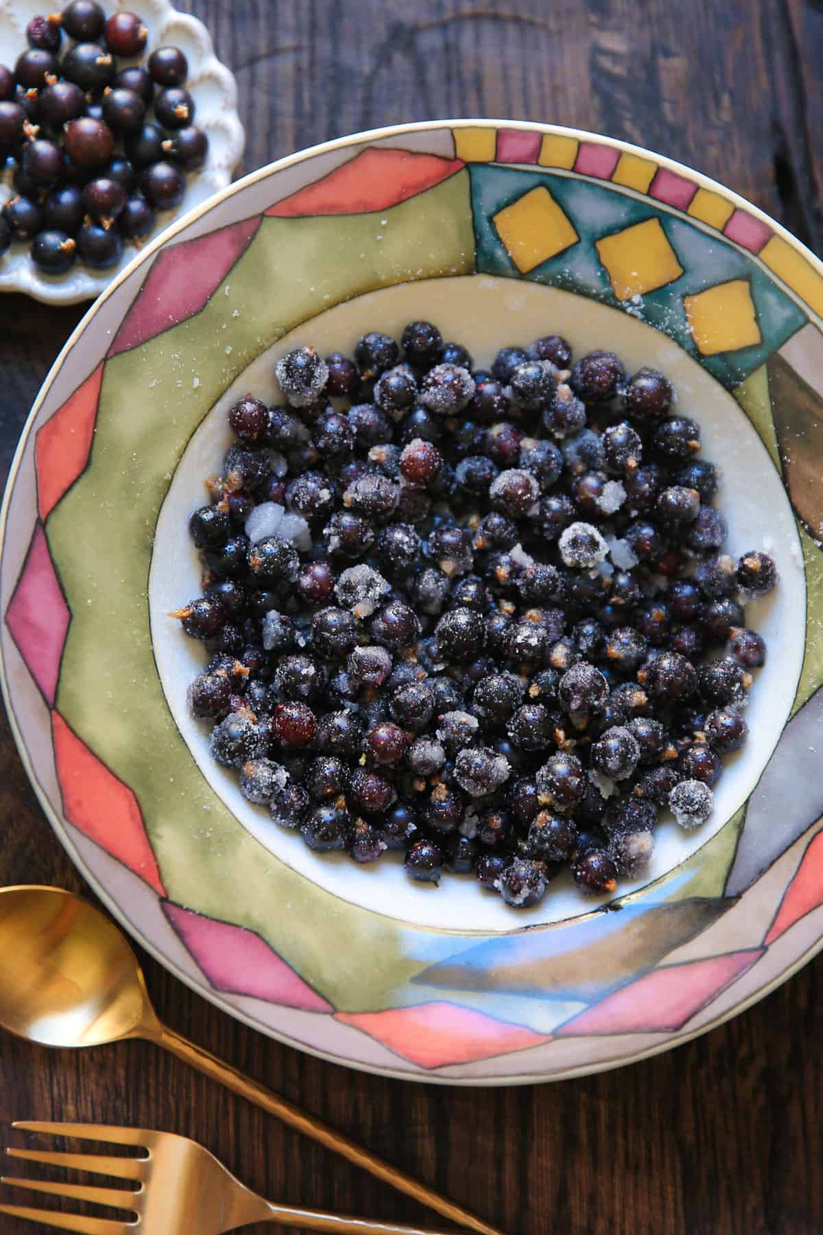 black currants mixed with sugar in a bowl.