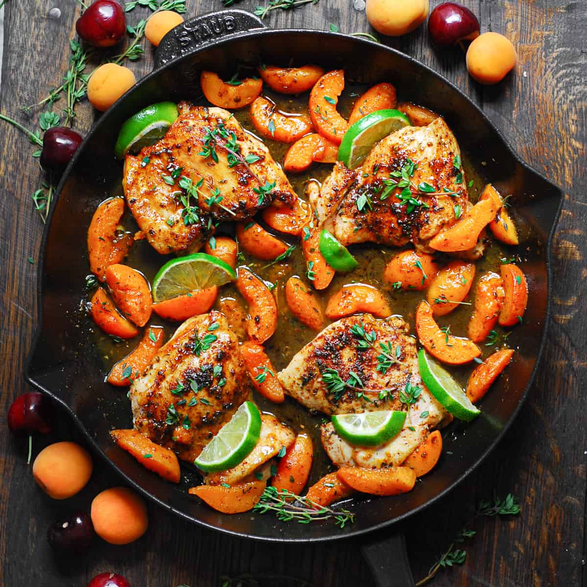 Chicken with cooked sliced Apricots, Honey-Lime Sauce, garnished with lime slices - in a cast iron skillet.