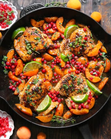 Chicken with Red Currants, Apricots, Honey-Lime Sauce, and Lime Slices - in a cast iron skillet.
