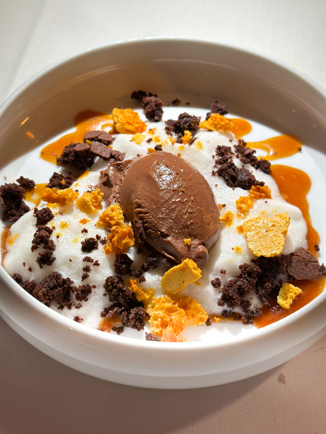 Ciccolata (Chocolate Dessert with Buttermilk Foam, Fudgy Brownie, Honey Comb, and Caramel) in a white bowl - at Cafe Monarch in Scottsdale AZ.