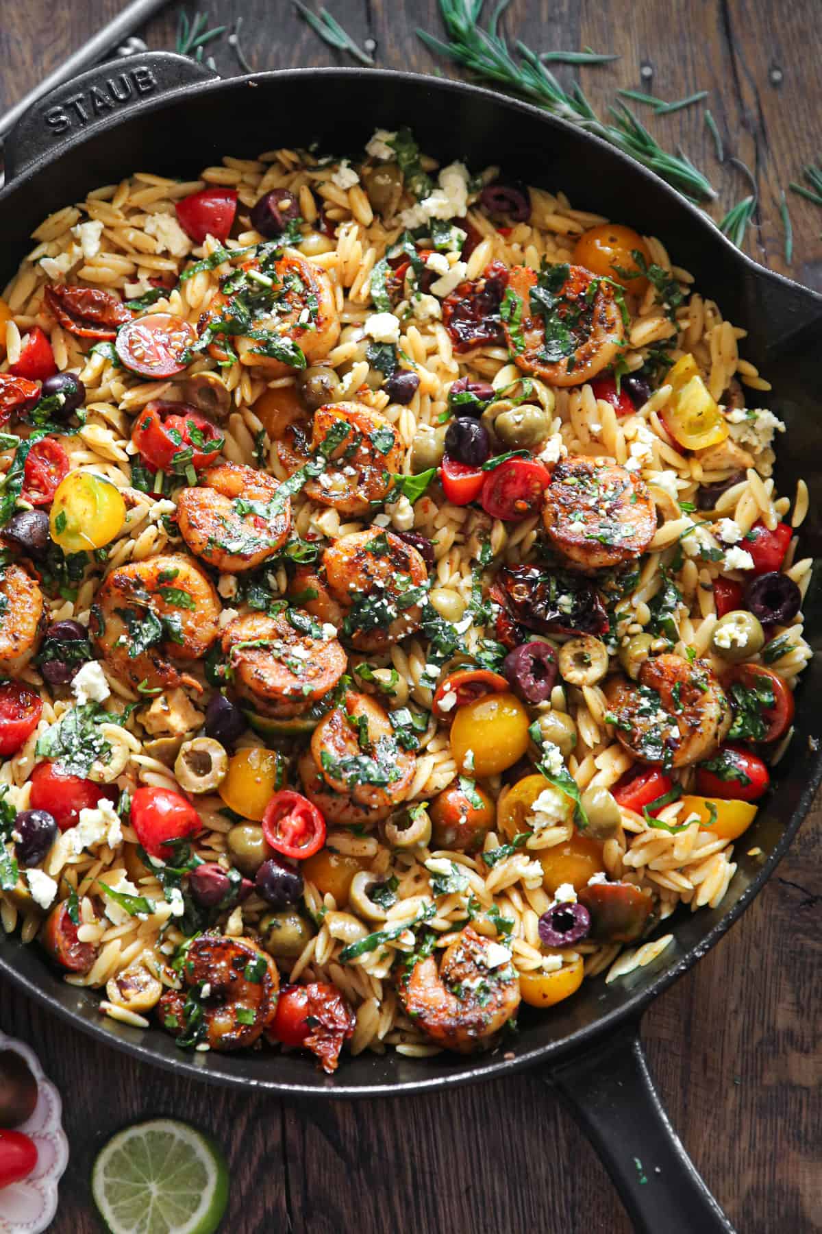 Greek Shrimp with Orzo, Feta, Olives, Sun-Dried Tomatoes, Cherry Tomatoes - in a cast iron skillet.