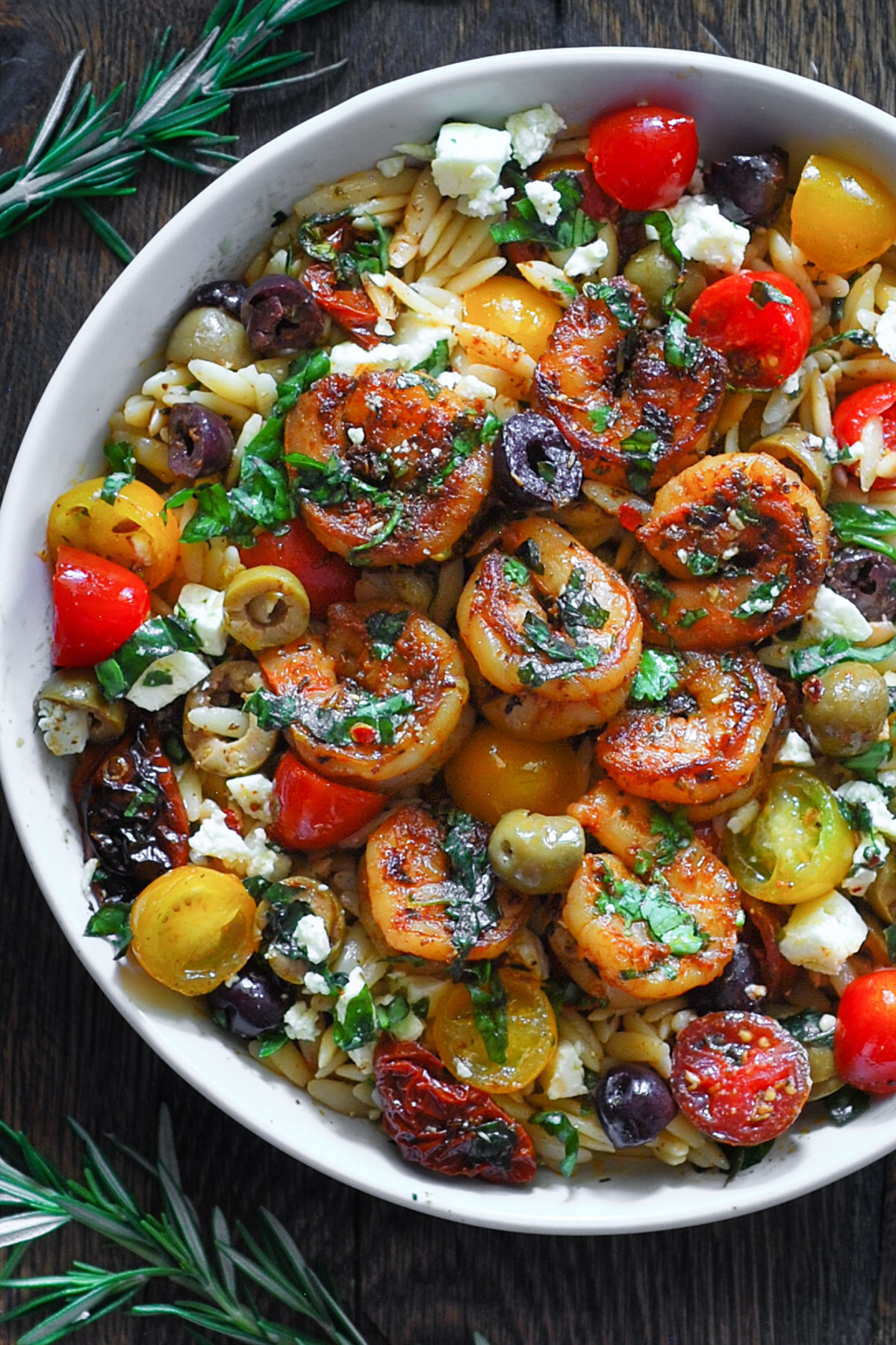 Greek Shrimp with Orzo, Feta, Olives, Sun-Dried Tomatoes, Cherry Tomatoes - in a white bowl.