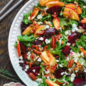 Beet and Apple Salad with Mixed Greens, Pecans, Blue Cheese - in a white bowl.