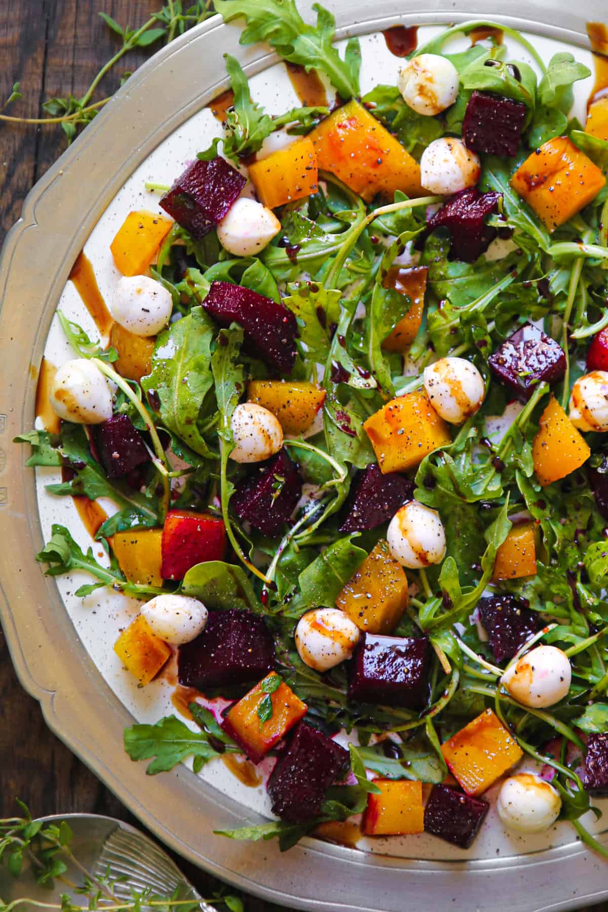 Beet and Mozzarella Cheese Salad with Arugula and Balsamic Dressing - on a white plate.