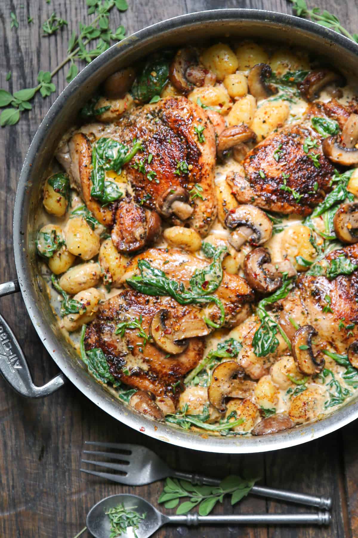 Creamy Chicken Gnocchi with Spinach and Mushrooms in a stainless steel pan.