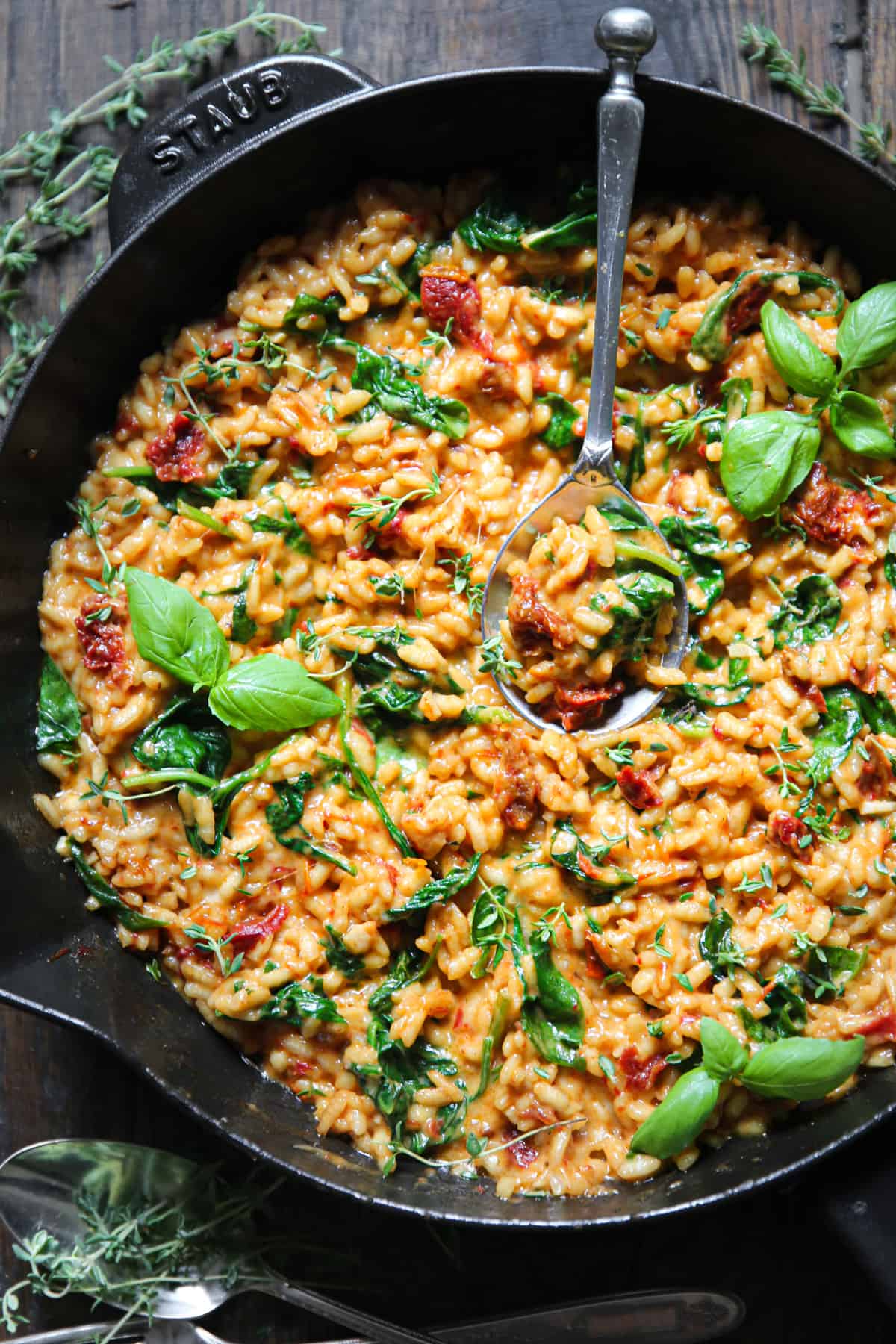 Sun-Dried Tomato Risotto with Spinach with the spoon in a cast iron skillet