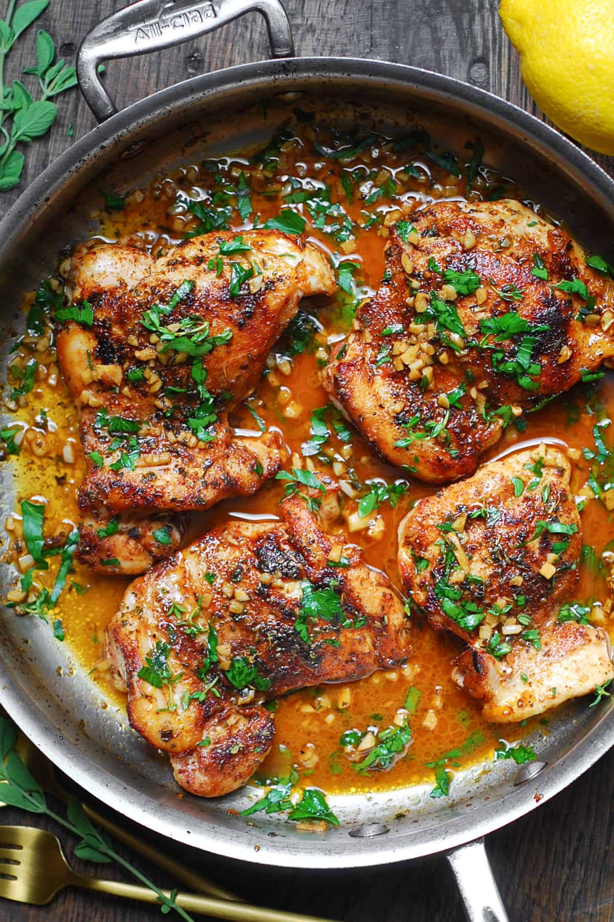 cajun chicken with garlic lemon butter sauce in a stainless steel pan.
