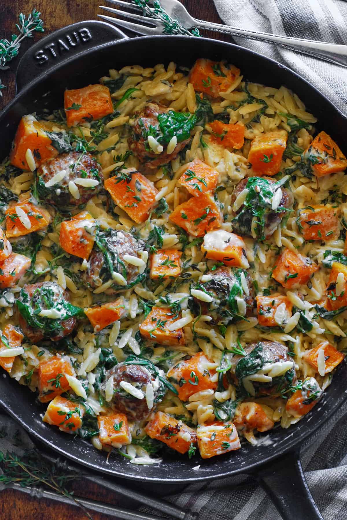 Baked Chicken Meatballs with Creamy Orzo, Roasted cubed Butternut Squash and Spinach - in a cast iron skillet.