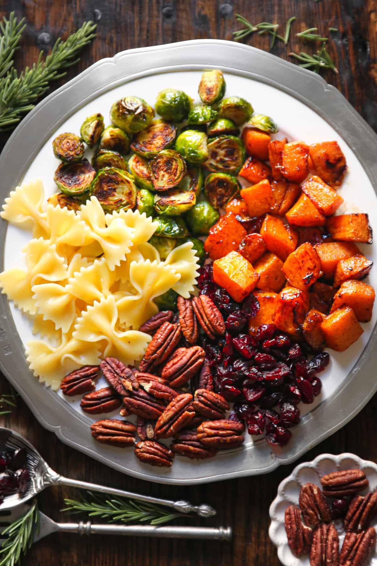 Butternut Squash Pasta Salad with Brussels Sprouts, Pecans, and Cranberries on a white plate.