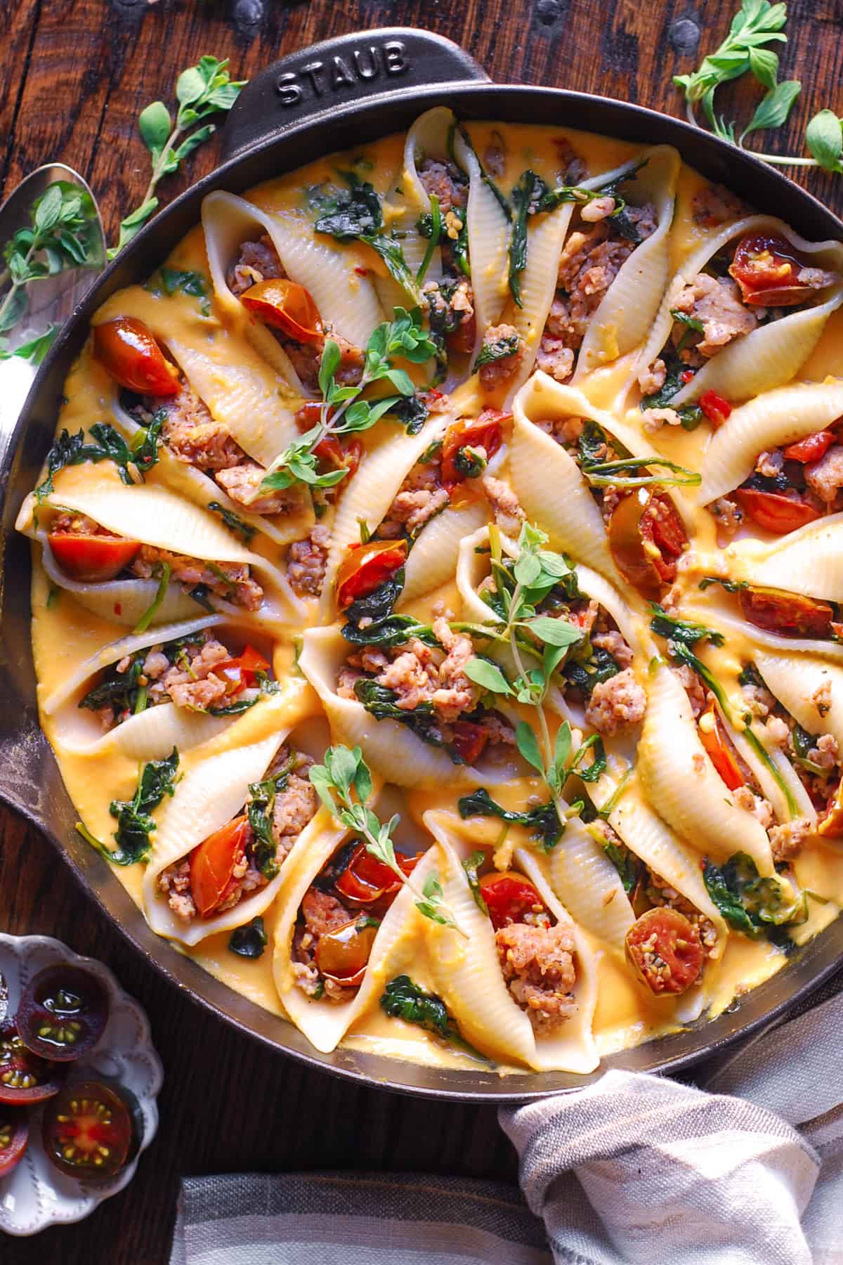 Butternut Squash Pasta Shells Stuffed with Sausage, Spinach, Tomatoes in a cast iron skillet.