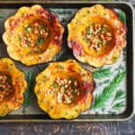 Roasted Acorn Squash with Pine Nuts on a baking sheet.