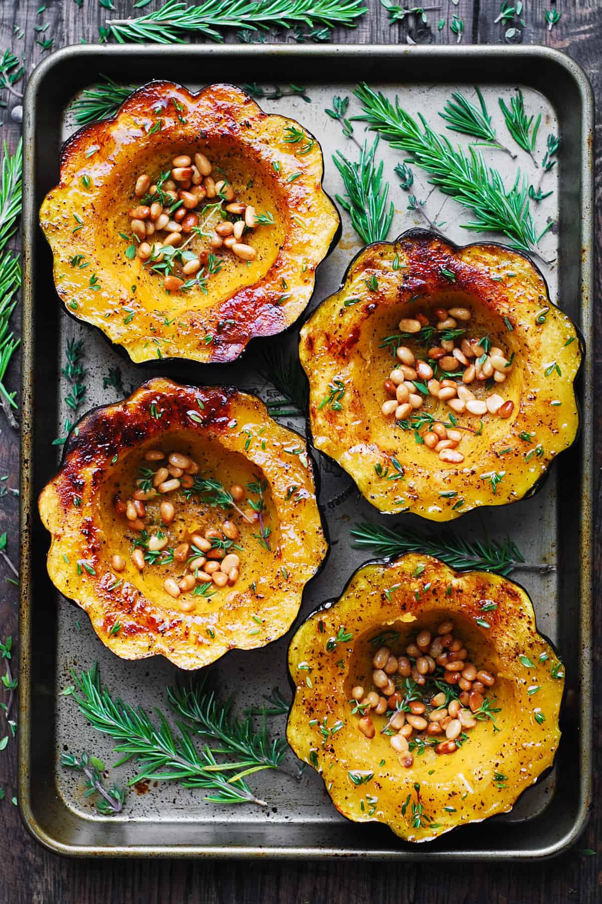 Roasted Acorn Squash with Pine Nuts on a baking sheet.