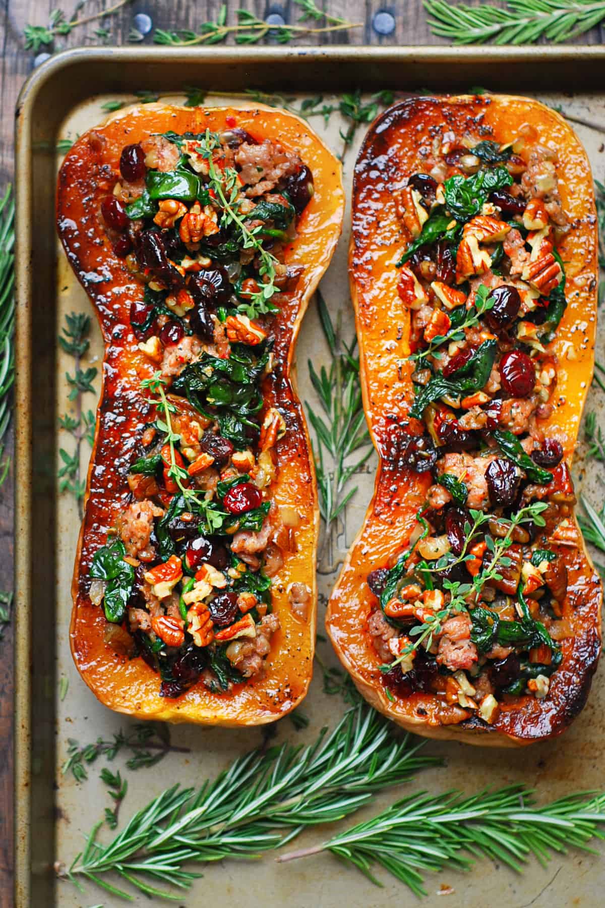 Sausage Stuffed Butternut Squash with Spinach, Pecans, and Cranberries on a baking sheet.