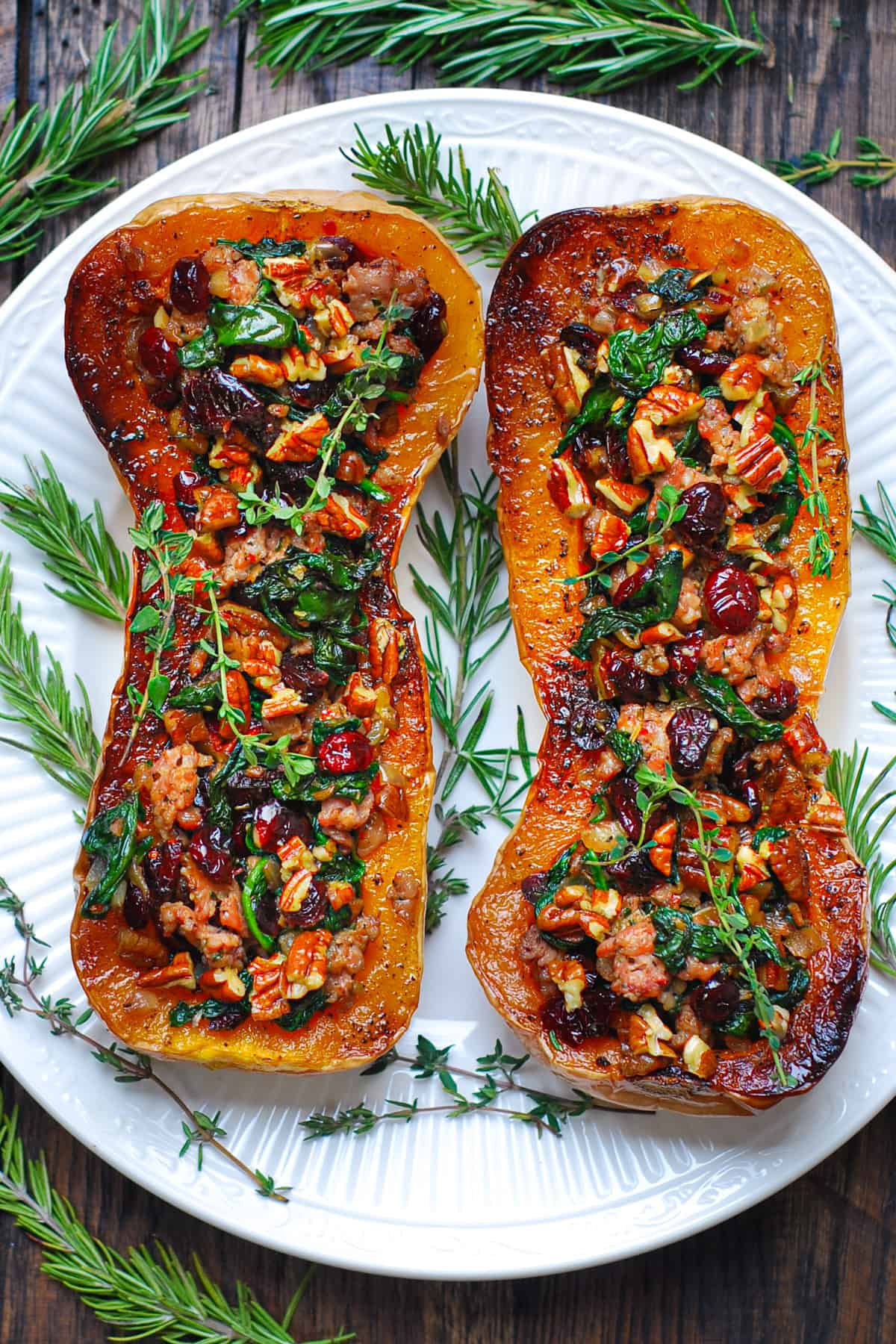 two Sausage Stuffed Butternut Squash halves on a white plate.
