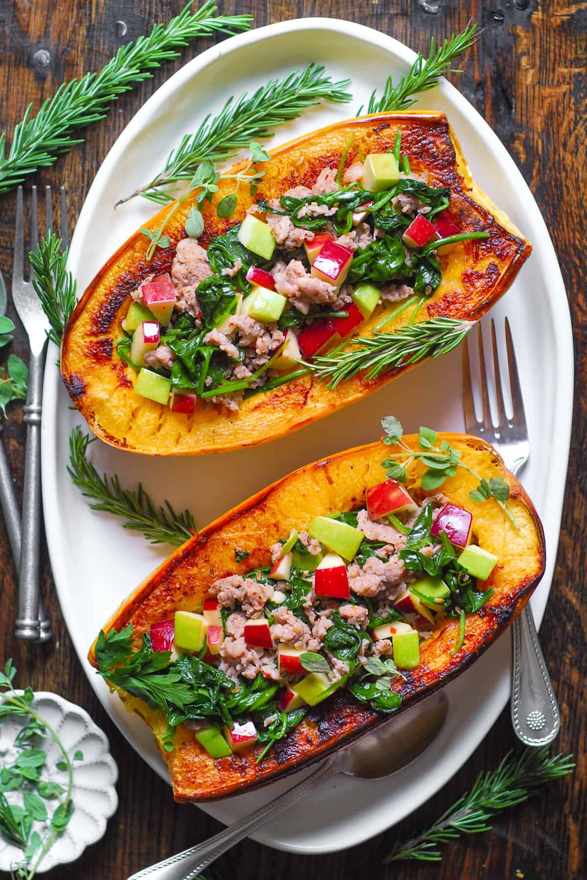 Stuffed Spaghetti Squash with Sausage, Spinach, Apples on a white platter.