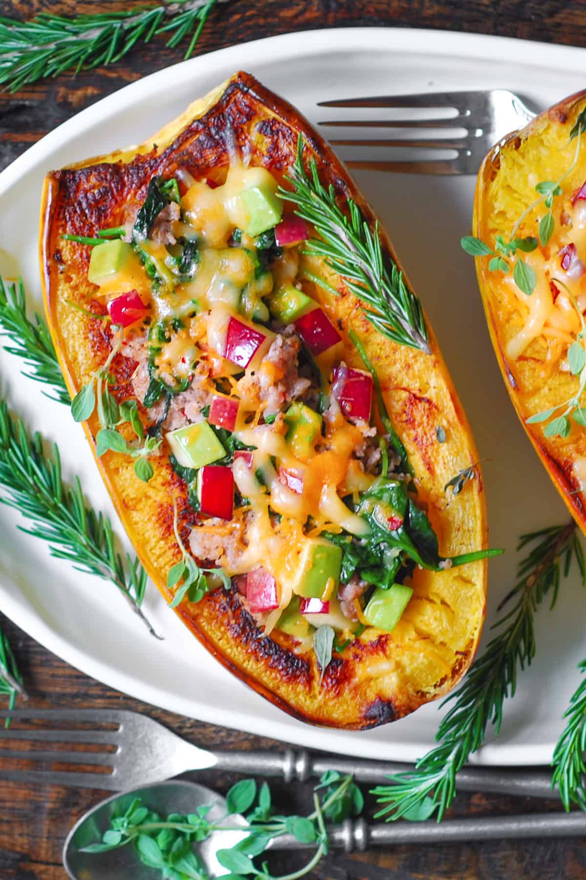 Stuffed Spaghetti Squash with Sausage, Spinach, and Apples on a white platter.