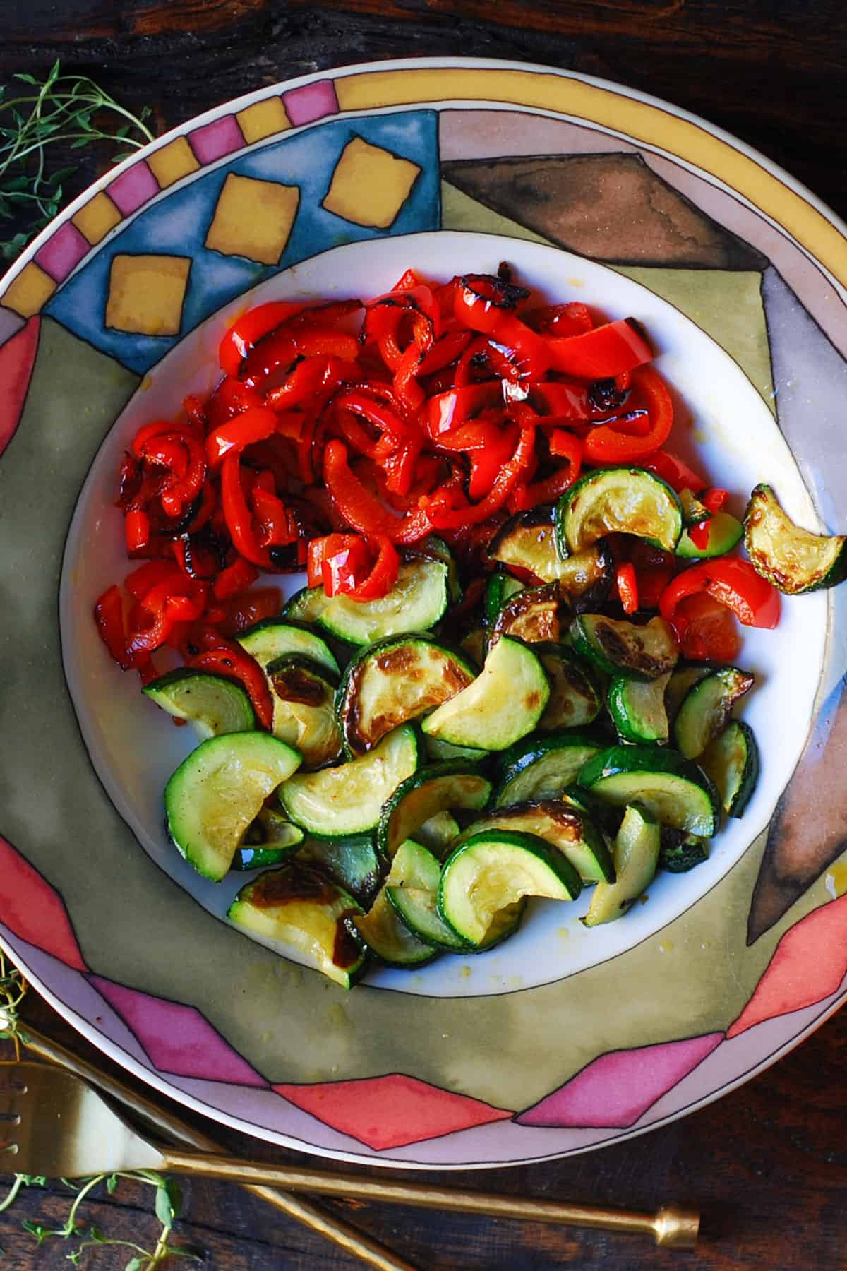Cooked sliced bell peppers and zucchini in a bowl.