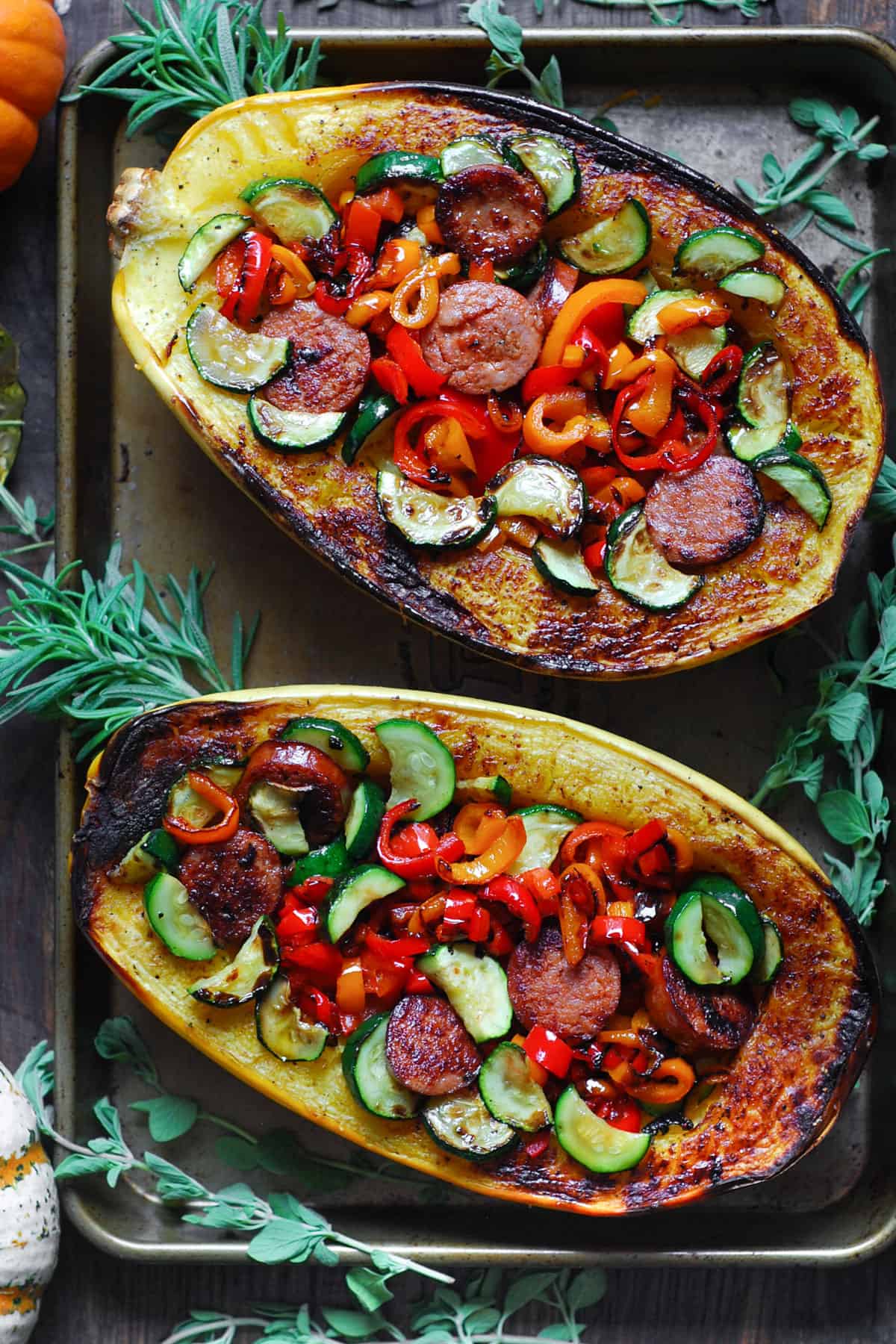 Stuffed Roasted Spaghetti Squash (2 halves) with Smoked Sausage, Roasted Bell Peppers, and Zucchini - on a baking sheet.