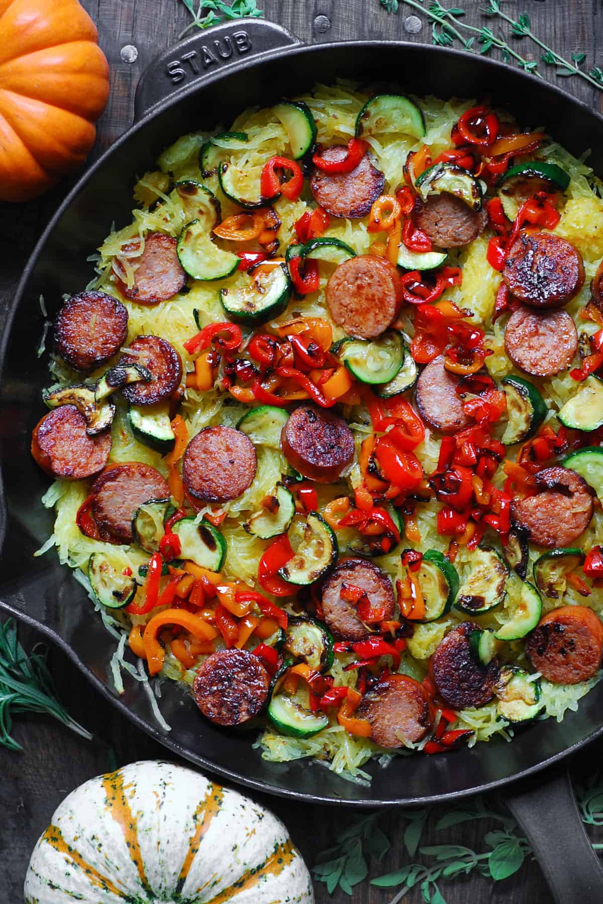 Scooped-out roasted spaghetti squash flesh, sliced smoked sausage, sliced cooked bell peppers, and zucchini - in a large cast iron skillet. 