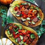 stuffed spaghetti squash (2 halves) with sausage, bell peppers, zucchini - on a white platter.