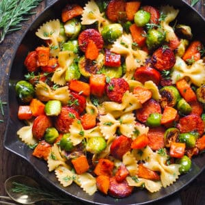 Autumn Dinner with Sausage, Pasta, Veggies (Butternut Squash and Brussels sprouts) in a cast iron pan.