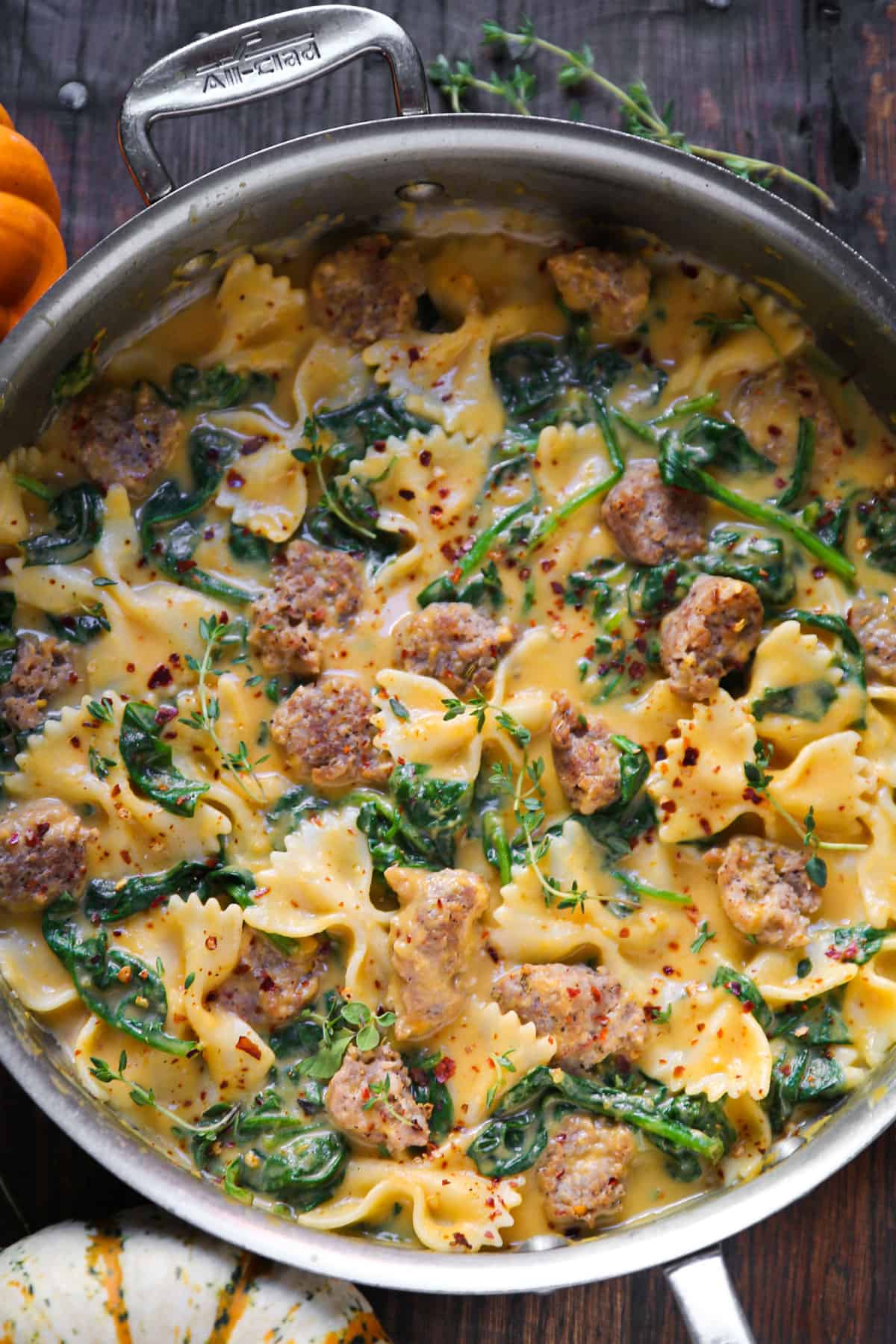 Creamy Butternut Squash Italian Sausage Bow-Tie Pasta with Spinach - in a stainless steel pan.