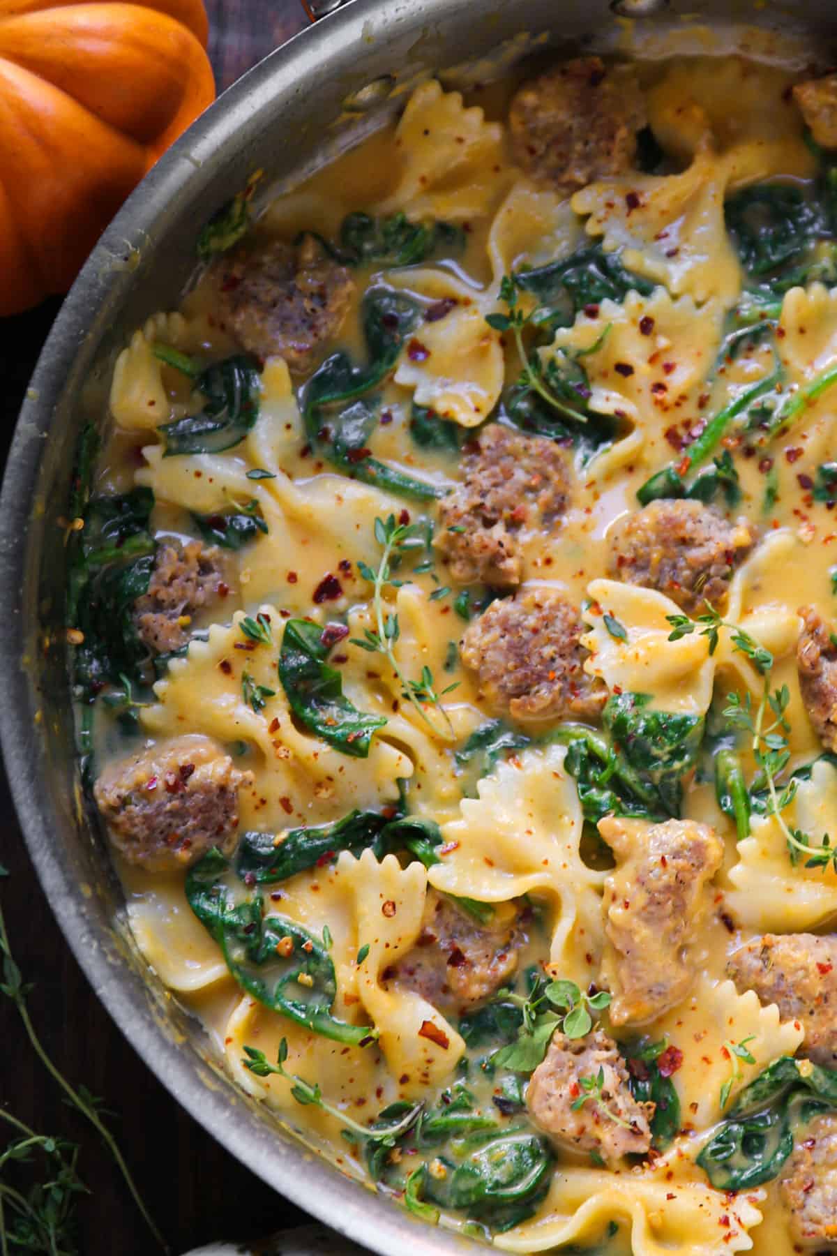 Creamy Butternut Squash Italian Sausage Bow-Tie Pasta with Spinach - in a stainless steel pan.