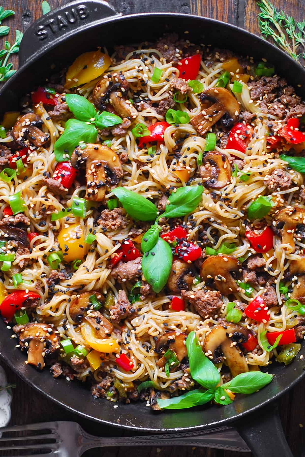 Ground Beef Ramen Noodles with Bell Peppers and Mushrooms in a cast iron pan.