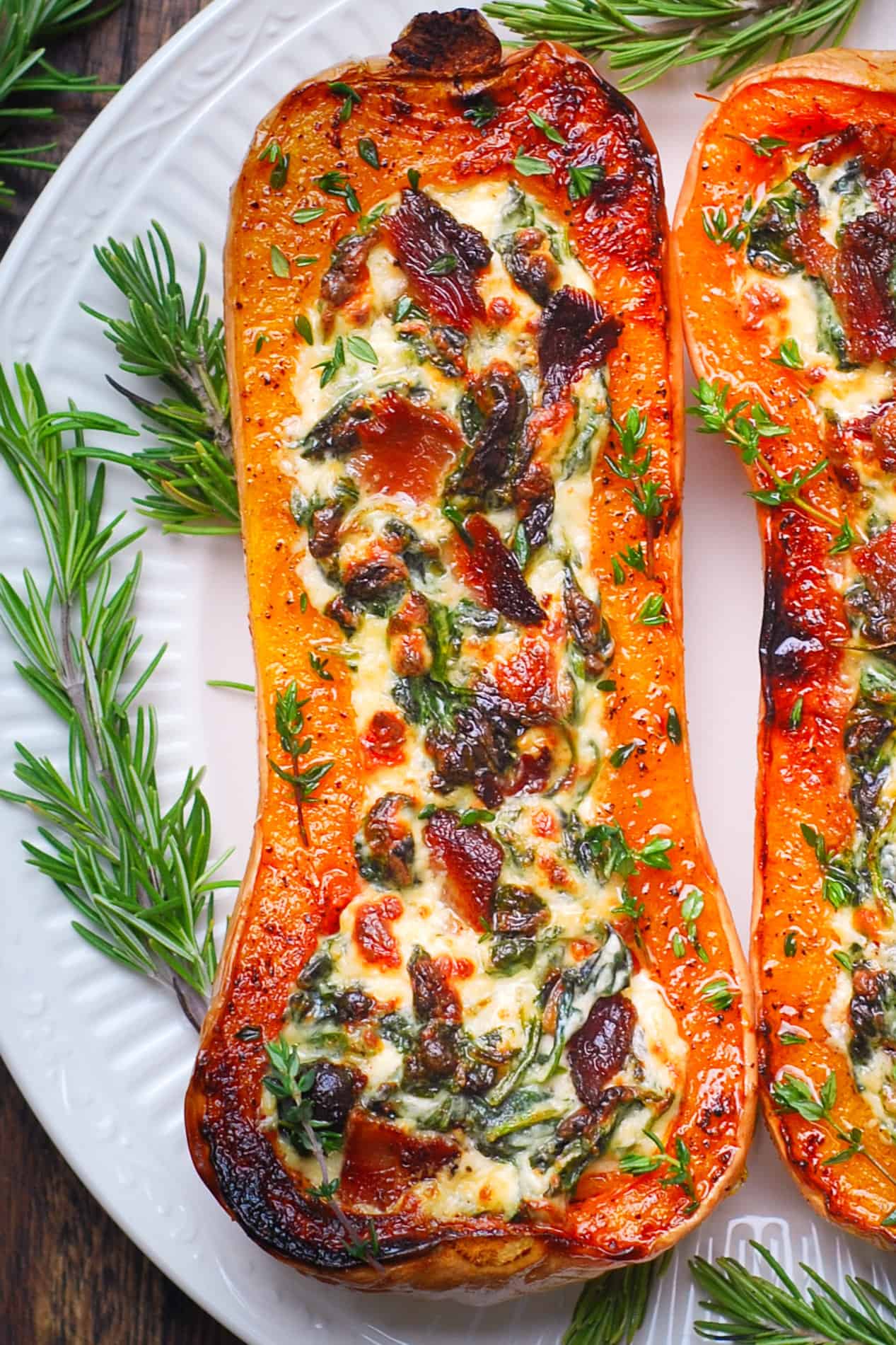 Stuffed Butternut Squash with Spinach, Bacon, and Cheese - on a white plate.