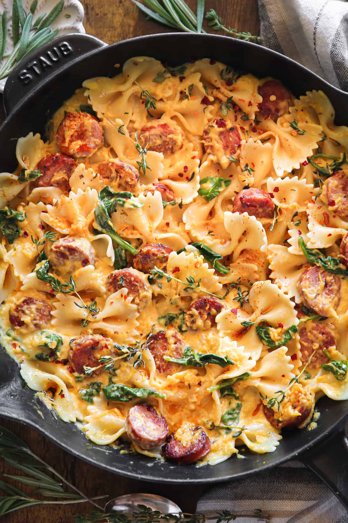 Creamy Acorn Squash Pasta with Sausage and Spinach in a cast iron skillet.