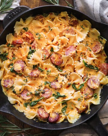 Creamy Acorn Squash Pasta with Sausage and Spinach in a cast iron skillet.