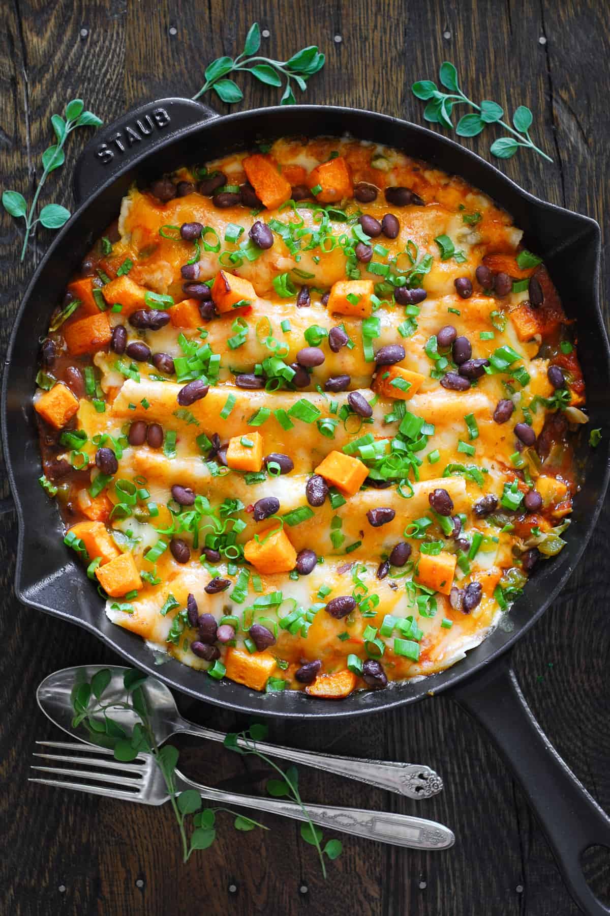 Vegetarian Enchiladas with Butternut Squash and Black Beans in a cast iron pan.