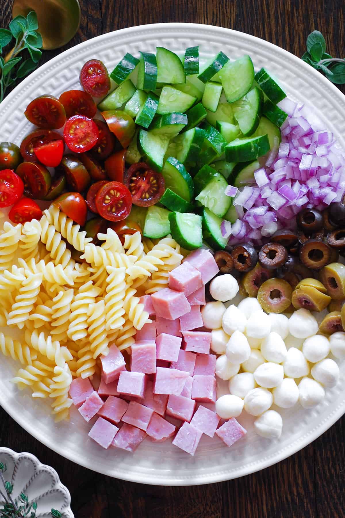 ham pasta salad ingredients on a white plate.