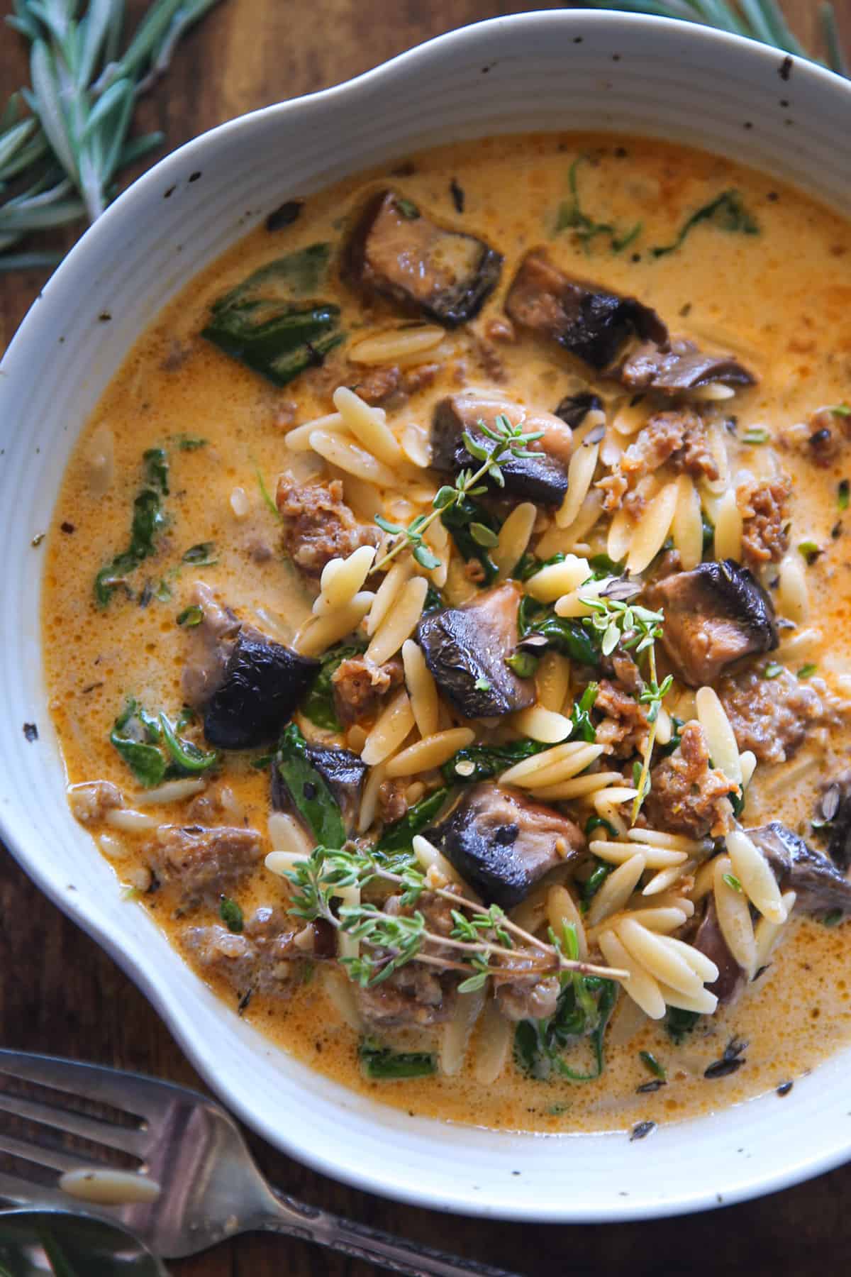 Sausage Orzo Soup with Spinach and Mushrooms in a white bowl.