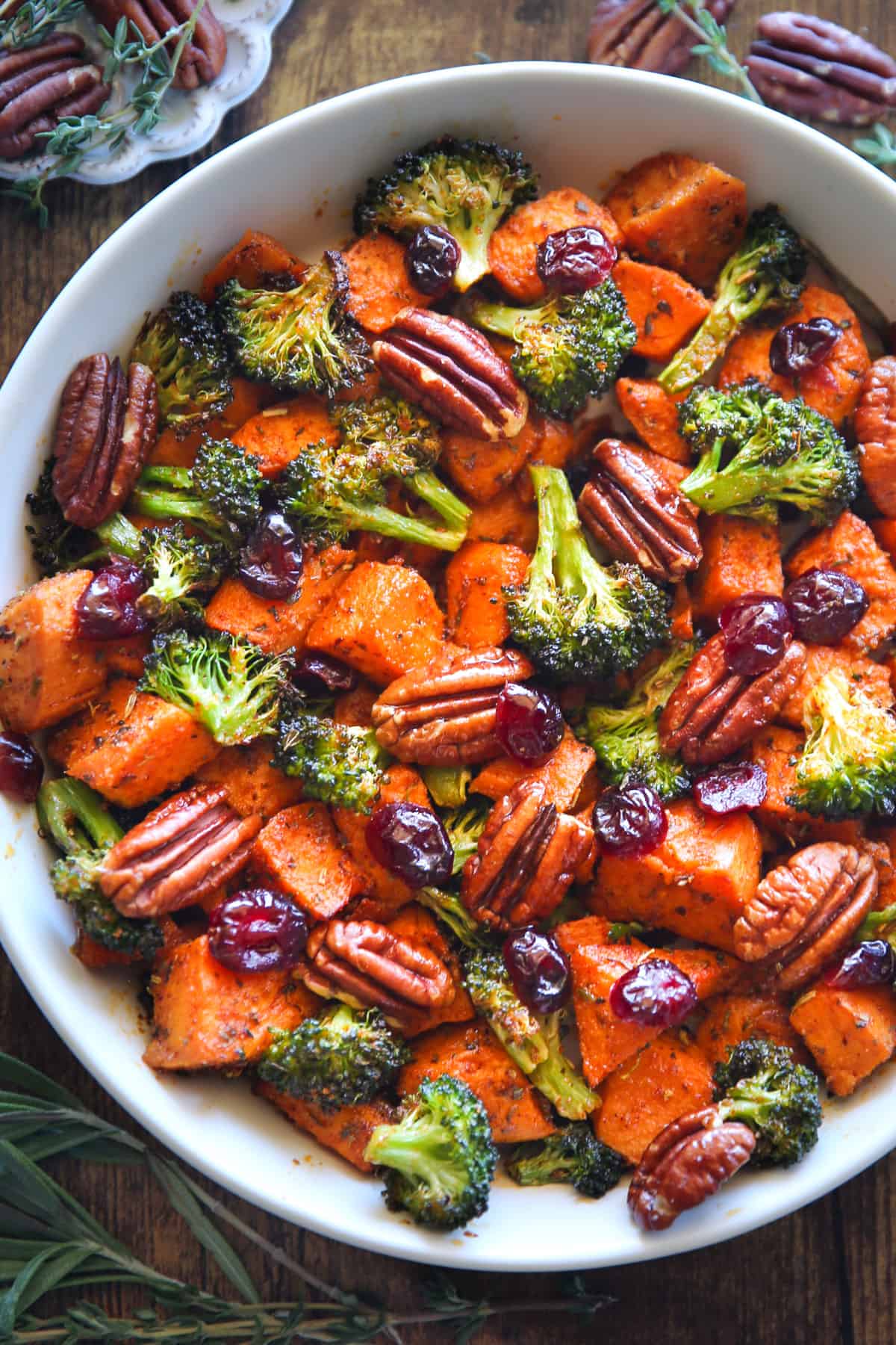 Sweet Potatoes, Broccoli, Pecans, and Cranberries in a white bowl.