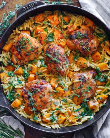 Chicken Orzo with Butternut Squash and Spinach in a cast iron skillet.