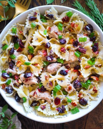 Chicken Pasta Salad with Pecans, Cranberries, Green Onions, and Creamy Poppy Seed Dressing in a white bowl.