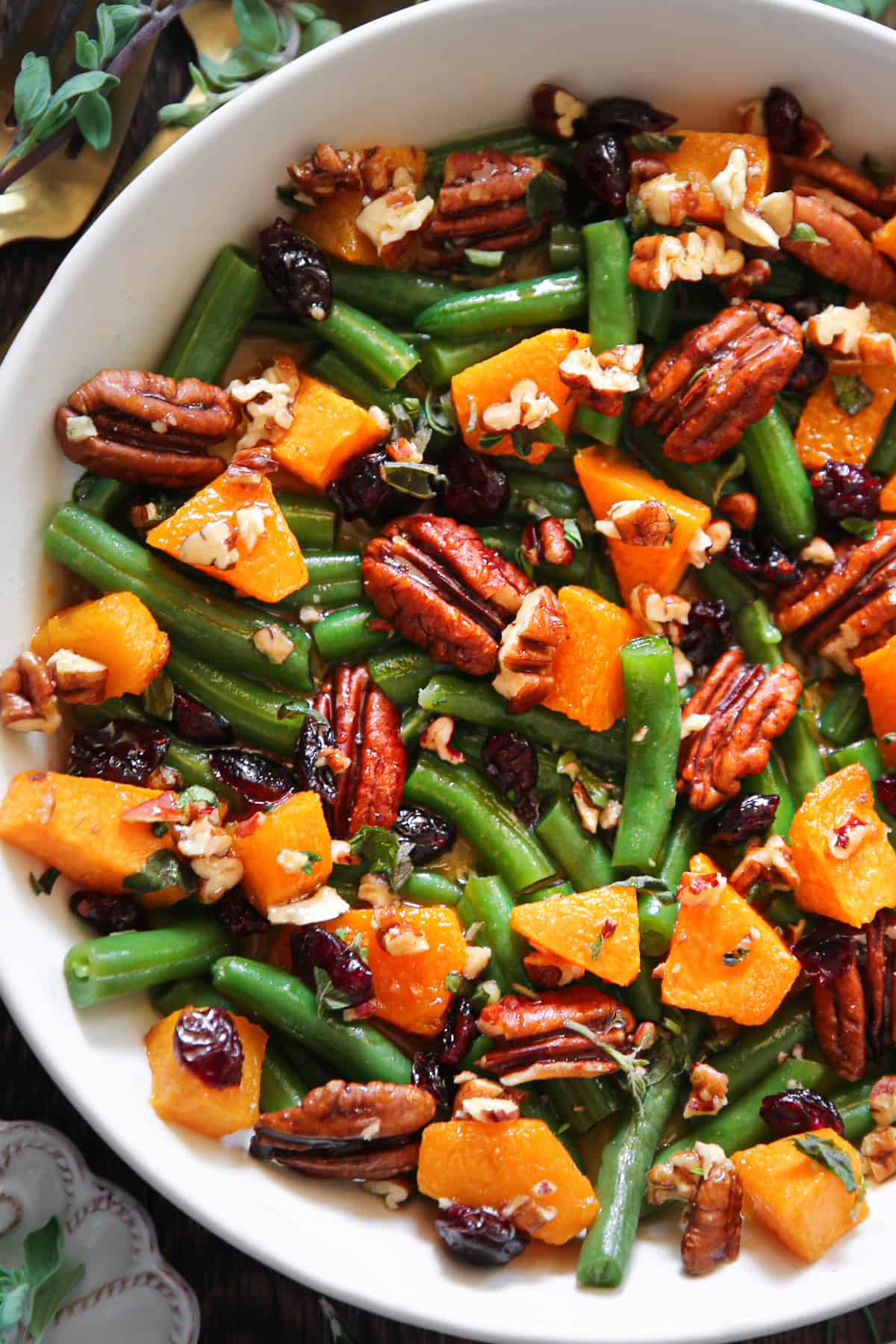 Green Beans with Butternut Squash, Pecans, and Cranberries in a white bowl.